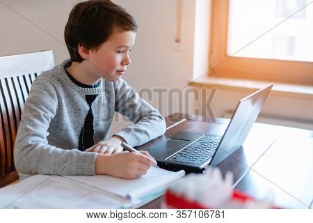 Pupil learning from home during crisis in video chat on laptop with teacher