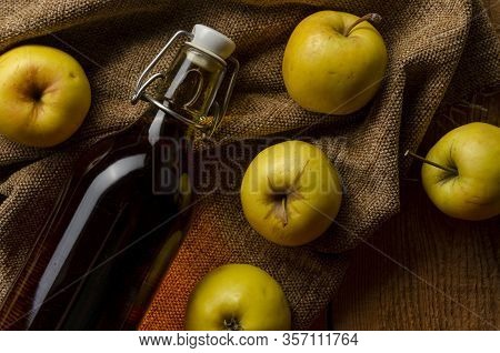 Full Bottle Of Cider With Basket Of Yellow Apples.