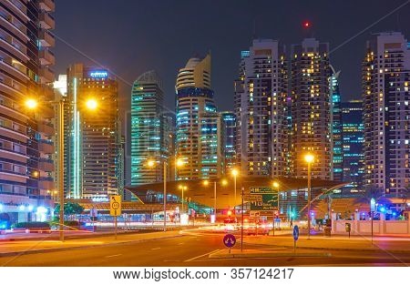 Dubai, UAE - January 30, 2020: DAMAC Metro Station and modern towers along Sheikh Zayed road in Dubai at night, United Arab Emirates                               