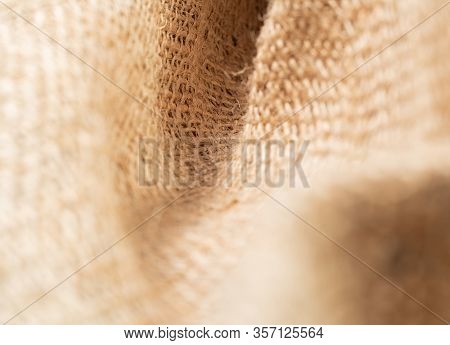 Close Up View On Crumpled Sackcloth. Brown Burlap Fabric, Abstract Background. Texture Of Brown Bali