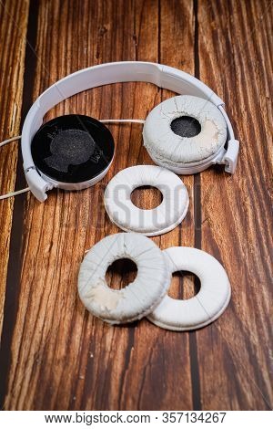 Need A Replacement Embouchures On Old White Earbud. Repair Accessories.wooden Background