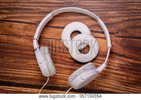 Need A Replacement Embouchures On Old White Earbud. Repair Accessories.wooden Background