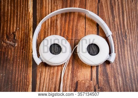 Need A Replacement Embouchures On Old White Earbud. Repair Accessories.wooden Background