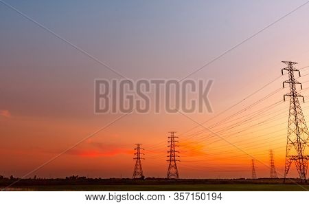 High Voltage Electric Pylon And Electrical Wire With Sunset Sky. Electricity Poles. Power And Energy