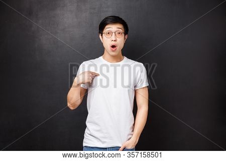 Portrait Of Surprised Confused Handsome Asian Guy Being Chosen Or Named, Pointing Himself With Disbe