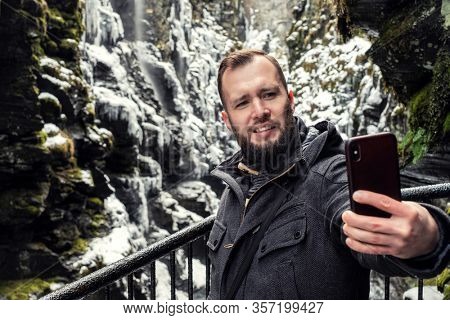 Tourist taking selfie in Bordalsgjelet gorge in Voss, Norway.