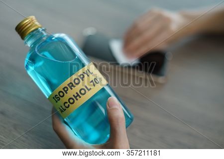 Hand With Isopropyl Alcohol For Clean Mobile Phone, Corona Virus Or Covid-19 Protection.