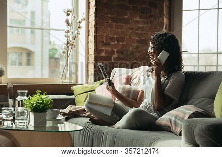 Talking On Phone. Woman, Freelancer During The Work In Home Office While Quarantine. Young Female Bu
