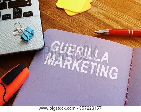 Guerilla Marketing Guide And Laptop On The Desk.