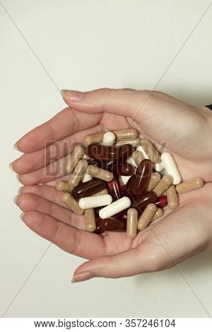 Female Hand Holds A Tablet, Capsule In Hands. On White Background. Pharmaceuticals. Allopathic Medic
