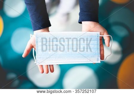 Protective Face Mask In Children Hands. Photo For Articles Abour Coronavirus, Flu, Healthcare, Medic