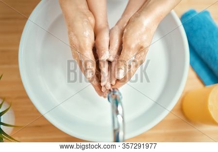 Kid and adult are washing their hands. Protection against infections and viruses. Close up.                                  