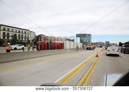 Irvine, California / USA - March 18, 2020: Semi Truck and Cargo on its side on the freeway after an accident in Irvine California. Traffic is Diverted and causing Traffic Jams due to an accident.
