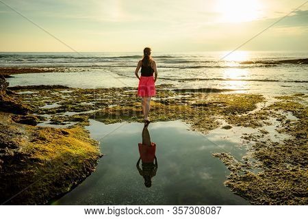 Woman Enjoying Sunset At The Beach. View From Back. Sunset Time. Caucasian Young Woman Standing At T