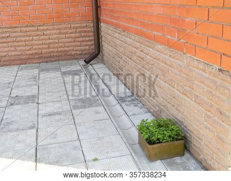 House Rain Gutter Drain Pipe With Draine Tranch On The Pavement