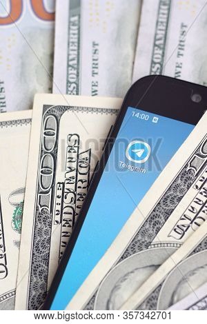 Smartphone Screen With Telegram App And Lot Of Hundred Dollar Bills. Business And Social Networking 