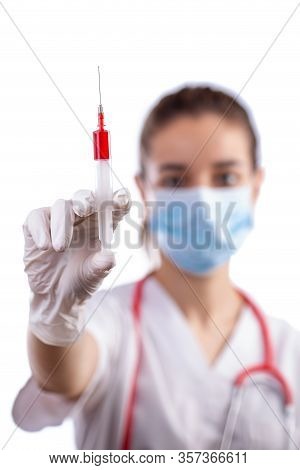 Girl Nurse In Mask Holding Syringe. Selective Focus