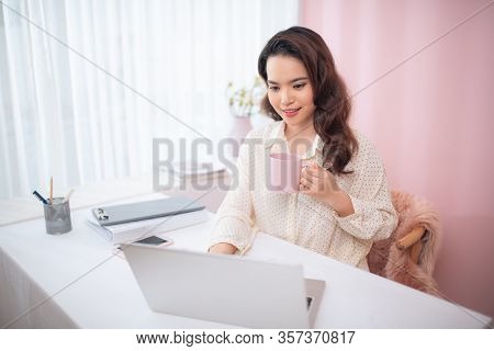 Protrait Of Beautiful Businesswoman Sitting At Desk And Working With Laptop Computer.