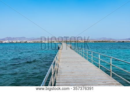 Long Pontoon On The Red Sea In Egypt. Pontoon For Descent Into The Water.