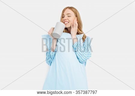 Beautiful Girl In Striped Pajamas, With A Cup In Her Hands , Drinking Coffee Or Tea In The Early Mor