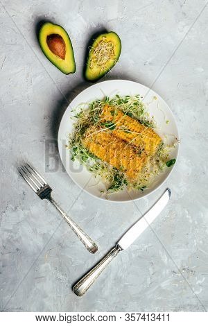 Cooked Sweet Corn With Green Alfalfa Sprouts On Plate And Avocado And Silver Fork And Knife On White
