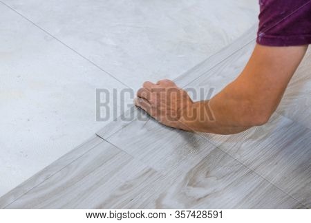 Work On Laying Worker Installing New Vinyl Tile Laminate Wood Texture Floor.