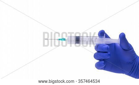 A Hand In A Blue Medical Glove Holds A Syringe Horizontally, White Background, Object Isolated