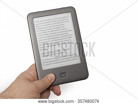 Holding E-book Reader In Hand. Include Clipping Path For Screen And Book With Hands. Lorem Ipsum Tex