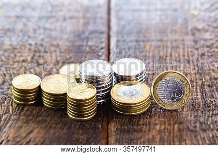 Coins From One Real On A Well Lit Rustic Wooden Background. Personal Finance And Private Savings, Ca
