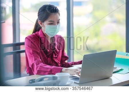 Female Employee Working And Wearing  Surgical Hygienic Mask On Her Face For Protect Herself From Dan