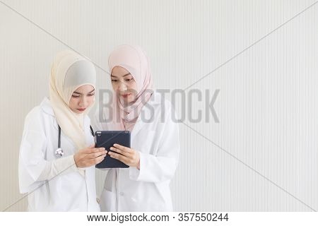 Two Attractive Young Beautiful Female Muslim Doctor Covered Face With Hijab Dress Using And Discussi