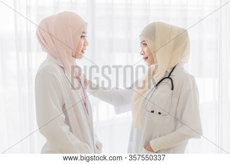 Attractive Young Beautiful Female Muslim Doctor Covered Face With Hijab Dress Talking With Familiar 