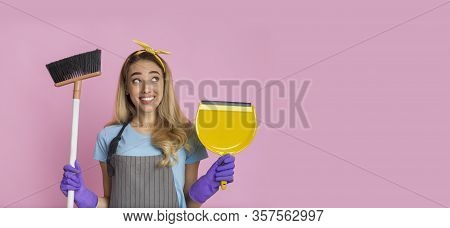 Young Beautiful Woman With Broom And Shovel Smiles On Pink Background