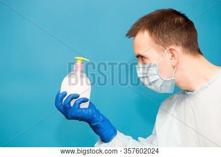 Doctor In Medical Suit Protective Mask And Gloves Washing Hands Before Operating Isolated On Blue Ba