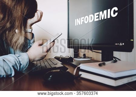 Coronavirus Infodemic Concept. Frightened Woman Sitting In Front Of Computer Monitor With Text Infod