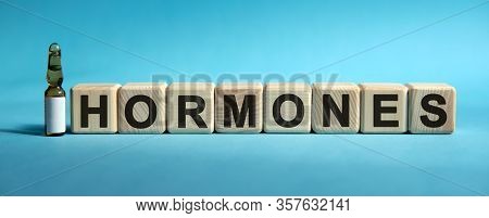 Hormones - Word On Cubes. Drug In Ambula To Reduce Disease Symptoms On A Blue Background
