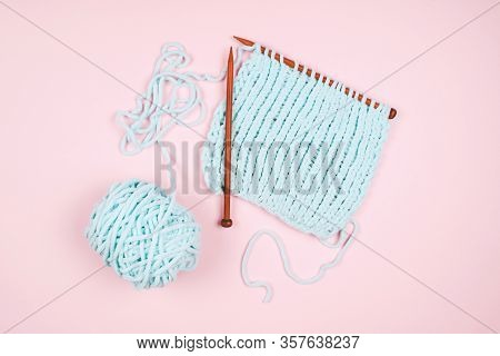 Mentol Yarn Ball And Wodden Knitting Needle On Light Pink Background