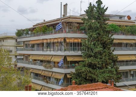 Greek Flags Waving On Balconies For A National Celebration. Blue And White Greek Flags With Cross Ou