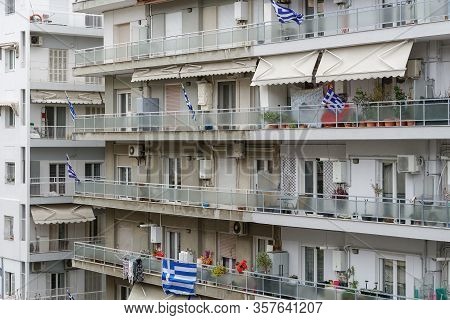 Greek Flags Waving On Balconies For A National Celebration. Blue And White Greek Flags With Cross Ou