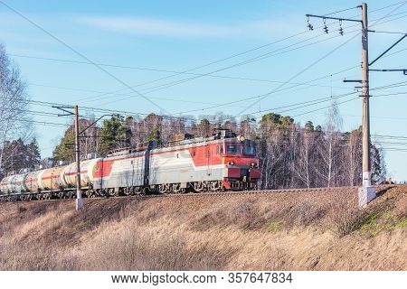 Freight Train Moves By The Forest At Spring Day Time.