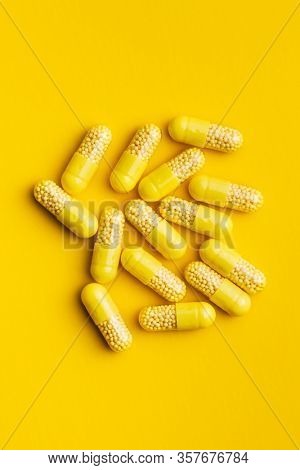 Vitamin capsules. Vitamin C pills on yellow background. Top view.