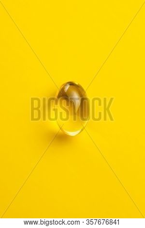 Omega 3 pills. Fish oil supplement capsules on yellow background. Top view.