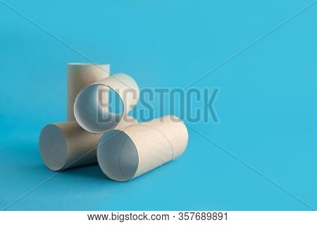 Empty Rolls Of Toilet Paper Sleeve Lie On A Blue Background. Place For Text. Panic With Lack Of Toil
