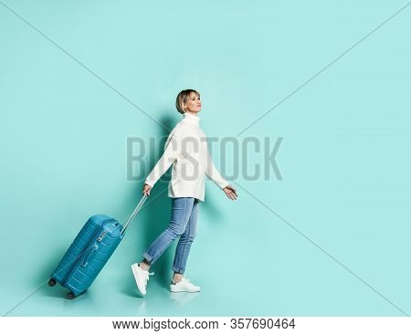 Attractive Blonde Girl In White Sweater, Jeans And Sneaker Smiling Posing With Suitcase Luggage Stan