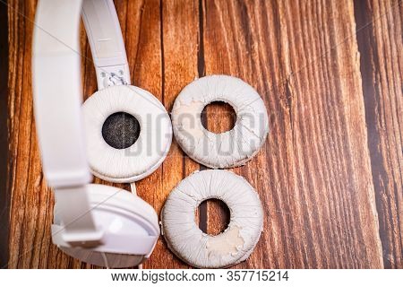 Need A Replacement Embouchures On Old White Earbud. Repair Accessories.wooden Background