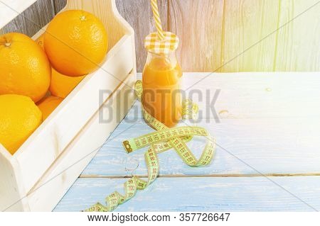 Lots Of Oranges And A Bottle Of Juice, Measuring Tape On A Wooden Textured Background. Fitness, Spor