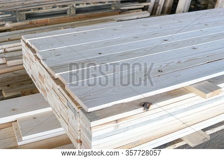 Pile Of Pine Wood In A Warehouse Or Storage Room. Wood Proceesing, Wood For Furniture