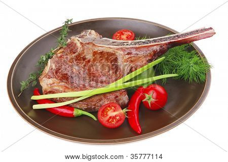 kyndel: grillad Reservdelar revben på mörka maträtt med timjan paprika och tomat isolerade över vit bakgrund