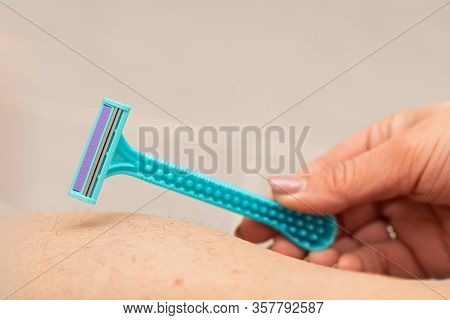 Close Up Picture Of Woman Holding Razor, Shaving Her Hairy Leg With Folliculitis