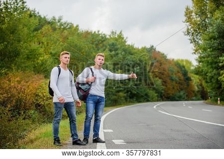 Type Of Adventure. On The Road. Enjoying Summer Hike. Looking For Transport. Twins Walking Along Roa